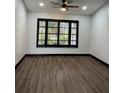 Spacious living room featuring dark hardwood floors and plantation shutters at 294 Rotonda Cir, Rotonda West, FL 33947