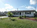 White one-story home with palm trees and well-maintained lawn at 3159 Pinetree St, Port Charlotte, FL 33952