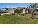 Single-story house with a lush green lawn and palm trees at 411 Boundary Blvd, Rotonda West, FL 33947