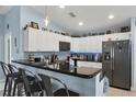 Modern kitchen with sleek black countertops, white cabinetry, and bar-style seating at 429 Rotonda Cir, Rotonda West, FL 33947