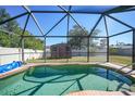 Screened-in pool with a wooden shed in the background at 6176 Catalan St, Englewood, FL 34224