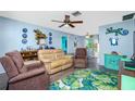 Bright living room featuring comfortable seating, leafy rug, and coastal decor at 7035 Sunnybrook Blvd, Englewood, FL 34224