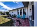 Charming patio with teal chairs, decorative accents, and red tile flooring at 7336 Brookhaven Ter, Englewood, FL 34224