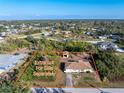 Aerial view of the property and adjacent lot, highlighting its location within a neighborhood with mature landscaping at 7522 Sea Mist Dr, Port Charlotte, FL 33981