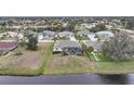 An aerial view of a property with a screened-in pool overlooking a tranquil waterfront at 8 Broadmoor Ln, Rotonda West, FL 33947