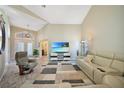 Open living room featuring a large sectional sofa and a modern TV at 8377 Parkside Dr, Englewood, FL 34224