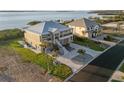 Beautiful two-story home with a modern metal roof, a spacious driveway, and well-manicured landscaping on a sunny day at 9861 Eagle Preserve Dr, Englewood, FL 34224