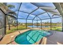 Relaxing kidney-shaped pool with screened enclosure offering tranquil water views at 1 Calm Ct, Placida, FL 33946