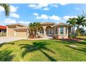 Tan house with attached garage and lush landscaping at 10544 Poughkeepsie Cir, Port Charlotte, FL 33981