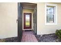 Inviting front entrance with red door and screened porch at 13489 Abercrombie Dr, Englewood, FL 34223