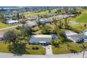 Aerial view showcasing a single story home with pool in a golf course community at 142 Caddy Rd, Rotonda West, FL 33947