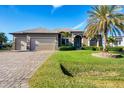 Single-story home with three-car garage and palm trees at 14201 Joggins Ave, Port Charlotte, FL 33981