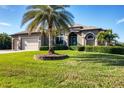 House exterior showcasing a palm tree and manicured lawn at 14201 Joggins Ave, Port Charlotte, FL 33981