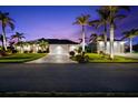 Night view of a single-Gathering home with palm trees and landscape lighting at 14216 Aurella Cir, Port Charlotte, FL 33981