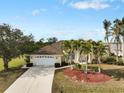 Single-story home with a two-car garage and lush landscaping at 2295 Chilcote Ter, Port Charlotte, FL 33981