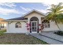 Front view of a house with a screened entryway and palm trees at 23111 Mineral Ave, Port Charlotte, FL 33954