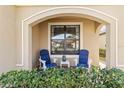 Cozy front porch with two blue chairs and a small side table at 24269 Spartina Dr, Venice, FL 34293