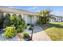 Inviting front entrance with lush tropical landscaping and a stylish blue door at 254 Mark Twain Ln, Rotonda West, FL 33947