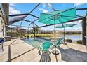 Screened pool and patio area with lake view, lounge chairs and umbrellas at 484 Casalino Dr, Nokomis, FL 34275