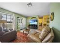 Inviting living room with decorative hutch, tile floors, wood floor accents, and large window at 6543 Coliseum Blvd, Port Charlotte, FL 33981