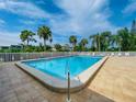 Inviting community pool with clear blue water and surrounding palm trees at 6800 Placida Rd # 122, Englewood, FL 34224