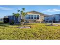 Yellow mobile home with carport and landscaping at 717 Tangerine Woods Blvd, Englewood, FL 34223