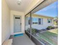 Inviting front entry with a gray door, screened porch, and landscaping at 7179 Lighthouse St, Englewood, FL 34224