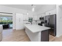 Modern kitchen featuring white cabinets, stainless steel appliances, and a large island at 7442 Clearwater St, Englewood, FL 34224