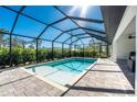 Relaxing pool area with a covered patio and lush landscaping at 7442 Clearwater St, Englewood, FL 34224