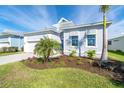 Light blue house with white garage, palm trees, and landscaping at 8768 Conch Ave, Placida, FL 33946