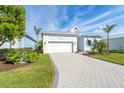 A charming one-story home with a white garage door and landscaped yard at 8768 Conch Ave, Placida, FL 33946