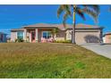 Inviting single-Gathering home with a well-manicured lawn, palm tree, and neutral color scheme at 9240 New Martinsville Ave, Englewood, FL 34224