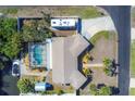 Aerial view shows a home with a screened pool, canal access, RV parking, shed and tropical foliage at 1005 E 2Nd St, Englewood, FL 34223