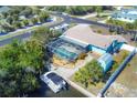 An aerial view showcasing a screened-in pool, canal access, RV parking, a shed, and lush tropical landscaping at 1005 E 2Nd St, Englewood, FL 34223