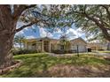 Charming single-story home showcasing mature trees, a well-kept lawn, and beautiful landscaping at 1216 Whitney Dr, Venice, FL 34293