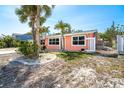 Charming single-story home with a well-manicured lawn featuring lush landscaping and mature palm trees at 1340 Holiday Dr, Englewood, FL 34223