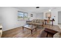 Cozy living room featuring wood-look floors, bright natural light, and comfortable seating at 1455 New Point Comfort Rd, Englewood, FL 34223