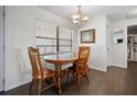 Cozy dining area with a round wood table set under an elegant light fixture and a view of the bathroom at 1493 New Point Comfort Rd, Englewood, FL 34223