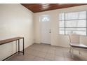 A simple entryway with wood ceiling, tile floors, and white walls at 1495 New Point Comfort Rd, Englewood, FL 34223
