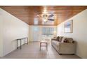 Open living room with wood plank ceiling, tile floors, and natural light at 1495 New Point Comfort Rd, Englewood, FL 34223