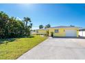 Well-maintained home with a lush lawn, driveway, and attached one-car garage at 275 North Dr, Englewood, FL 34223