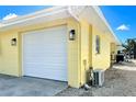 Attached garage featuring a new white garage door and updated outdoor lighting at 275 North Dr, Englewood, FL 34223