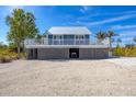 Charming elevated beach house with a metal roof and a deck overlooking the landscape at 331 Bocilla Dr, Placida, FL 33946