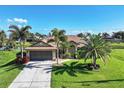 Single-Gathering home with a two-car garage and palm trees in the front yard at 39 Tournament Rd, Rotonda West, FL 33947