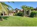 House exterior showcasing landscaping, palm trees and a two-car garage at 39 Tournament Rd, Rotonda West, FL 33947