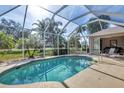 Relaxing screened-in pool with ample deck space for entertaining and lounging near lush landscaping at 604 Boundary Blvd, Rotonda West, FL 33947