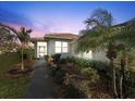 Well-maintained home exterior, featuring a walkway and lush landscaping at 6730 Greenview Ln, Englewood, FL 34224