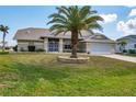 Single-story home with palm tree and driveway at 9238 Melody Cir, Port Charlotte, FL 33981
