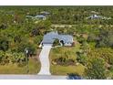 Aerial shot of a meticulously landscaped property showing a circular driveway, lush yard, and mature trees at 9350 Loyola Ave, Englewood, FL 34224