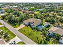 Aerial view of a suburban home with a screened-in pool, lush landscaping, and surrounding neighborhood at 9533 Arnaz Cir, Port Charlotte, FL 33981